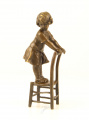 Bronzová soch holčičky v šatech na stoličce 
