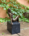 Bronzová socha polonahá sedící dívka